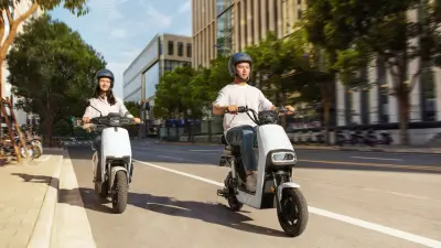 Couple riding electric scooters in a city.